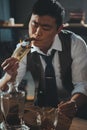 Asian businessman smoking cigar and burning dollar banknote