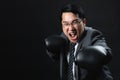 Asian businessman in suit and boxing gloves