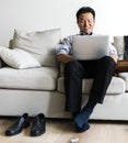 Asian businessman taking break laying on couch Royalty Free Stock Photo