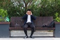 Asian businessman tired after work, sitting on a bench with fatigue and headache, has stress and panic attacks Royalty Free Stock Photo