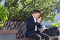 Asian businessman tired after work, sitting on a bench with fatigue and headache, has stress and panic attacks Royalty Free Stock Photo