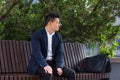 Asian businessman tired after work, sitting on a bench with fatigue and headache, has stress and panic attacks Royalty Free Stock Photo