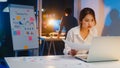 Asian businessman turn off computer and say goodbye his colleague who still working when he get off work after finish working. Royalty Free Stock Photo