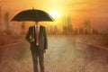 Asian businessman with an umbrella during a heatwave on the city with glowing sun background