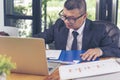 Asian Businessman using laptop at office desk. Man hands typing computer keyboard reading financial graph chart Planning analyzing Royalty Free Stock Photo