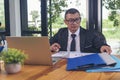 Asian Businessman using laptop at office desk. Man hands typing computer keyboard reading financial graph chart Planning analyzing Royalty Free Stock Photo