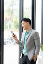 Asian businessman using smartphone and working at office desk using laptop and talking on mobile phone, Royalty Free Stock Photo