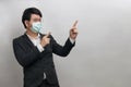 Asian businessman wear face mask and glasses with white shirt and black suite show two hands pointing finger, feeling happy, Royalty Free Stock Photo