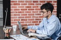 Asian businessman woking with laptop and paper work on desk at office.digital workflow online business lifestyle concept