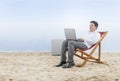 Asian businessman working with laptop sitting in the beach chair on beach Royalty Free Stock Photo