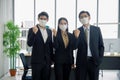 Asian businessmen and businesswoman are wearing mask at workplace to prevent the corona virus outbreak