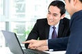 Asian businessmen discussing and looking at laptop computer