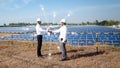 Asian businessmen standing check hand with the solar panel in the background. the idea of investors is cooperating in business on