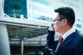 Asian businessmen wear glasses to phone and talk to customers.