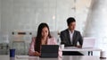 Businesspeople working with laptop and sitting together in modern office. Royalty Free Stock Photo