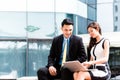 Asian businesspeople working outside on laptop