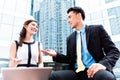 Asian businesspeople working outside on laptop