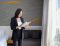 Asian businesswoman in black suit standing with tablet computer in her hand. Atmosphere of working outside the office during the Royalty Free Stock Photo