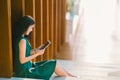 Asian businesswoman or college student using digital tablet during sunset, modern office or library scene Royalty Free Stock Photo