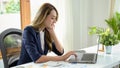 Asian businesswoman or a financial analyst focused on working on her project, using a laptop Royalty Free Stock Photo