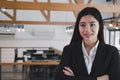 Asian businesswoman with folded hands smiling at camera. confide Royalty Free Stock Photo