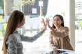 Asian businesswoman giving high five to colleague in meeting. Happy business professionals having meeting in office Royalty Free Stock Photo