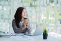 Asian businesswoman holding a cup of coffee working on investment projects and financial accounting planning strategies. Businessm Royalty Free Stock Photo