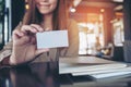 Businesswoman holding and showing an empty business card with notebooks on table Royalty Free Stock Photo