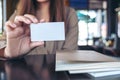 Businesswoman holding and showing an empty business card with notebooks on table Royalty Free Stock Photo