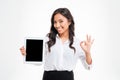 Asian businesswoman holding tablet with blank screen and showing okay