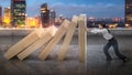 Asian businesswoman holds back the topple wooden block