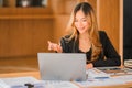 Asian businesswoman with laptop and financial graph in analyzing in office Beautiful girl with tablet computer Royalty Free Stock Photo