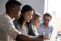 Asian businesswoman mentor teaching African American intern, using laptop