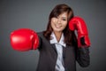 Asian businesswoman punch with boxing glove focus on the glove Royalty Free Stock Photo