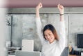 Asian businesswoman raise arm up stretching in front of desk fro