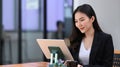 Businesswoman reading news on digital tablet while sitting in modern office. Royalty Free Stock Photo