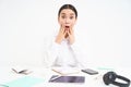 Asian businesswoman with shocked face, looks concerned and overwhelmed at camera, sits in office, white background Royalty Free Stock Photo