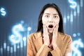 Asian businesswoman shocked looking dollar virtual bar chart