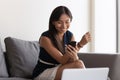 Asian businesswoman sit on couch in office using smartphone Royalty Free Stock Photo