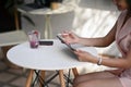 Asian businesswoman sitting in cafe and reading morning news via digital tablet. Royalty Free Stock Photo