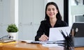 Asian businesswoman sitting at her office desk and smiling to camera Royalty Free Stock Photo