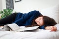 Asian businesswoman in suit working until asleep in bed. Royalty Free Stock Photo