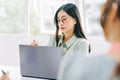 Asian businesswoman taking notes during the meeting