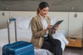 Businesswoman traveller sitting on bed using computer tablet in hotel room Royalty Free Stock Photo