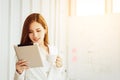 Businesswoman using a digital tablet standing in front of windows in city building Royalty Free Stock Photo