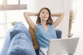 Asian businesswoman using laptop work at home stretch relax breathe fresh air on sofa. social distancing concept Royalty Free Stock Photo