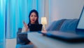 Asian businesswoman using tablet talk to colleagues about plan in video call while working from home at living room at night. Royalty Free Stock Photo