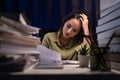 Asian businesswoman working hard late hours with a lot of document at home. She is busy and exhausted of work overtime at night Royalty Free Stock Photo