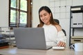 Asian businesswoman working at her desk, using laptop computer to manage her business tasks Royalty Free Stock Photo
