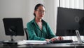 Asian businesswoman working in her office, typing on her computer